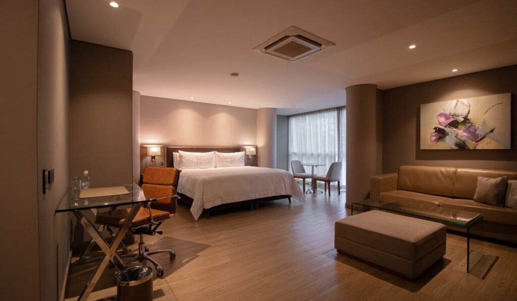 Suite de lujo del BINN Hotel con cama amplia, escritorio de trabajo y zona de estar contemporánea.