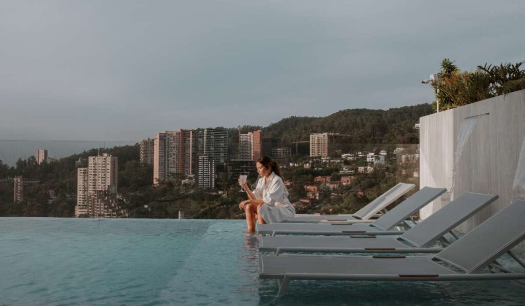 Mujer relajándose en la piscina del BINN Hotel con vistas a la ciudad de Medellín.
