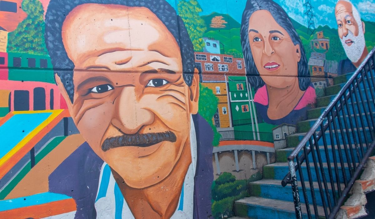 Mural de una familia pintado en la pared lateral de un edificio, mostrando la unidad y la diversidad familiar.