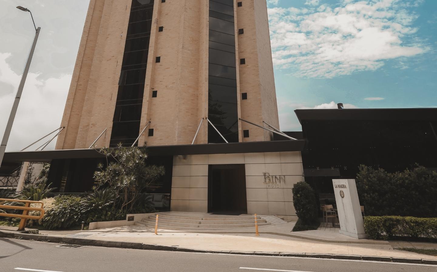 Edificio imponente de binn hotel con una torre del reloj grande, que marca la hora en el centro de la ciudad, destacando las Diferencias entre hotel boutique y hotel tradicional.