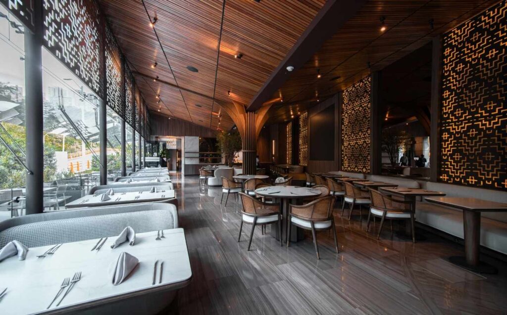 Restaurante con mesas y sillas frente a una gran ventana, creando un Diseño y atmósfera agradable