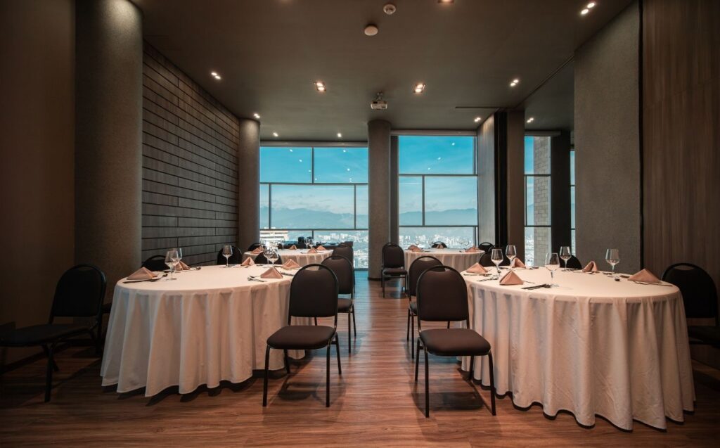 Vista de un restaurante con mesas y sillas listas para una cena especial, ideal para la organización de Eventos corporativos de lujo en Medellín.