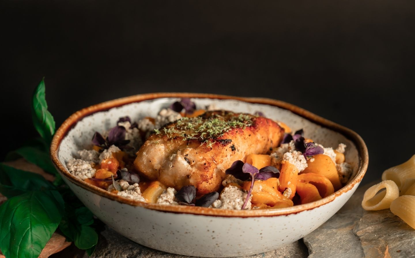 Un tazón de comida con carne y pasta, listo para disfrutar. Esta combinación incluye los ingredientes estrella de La Makha.