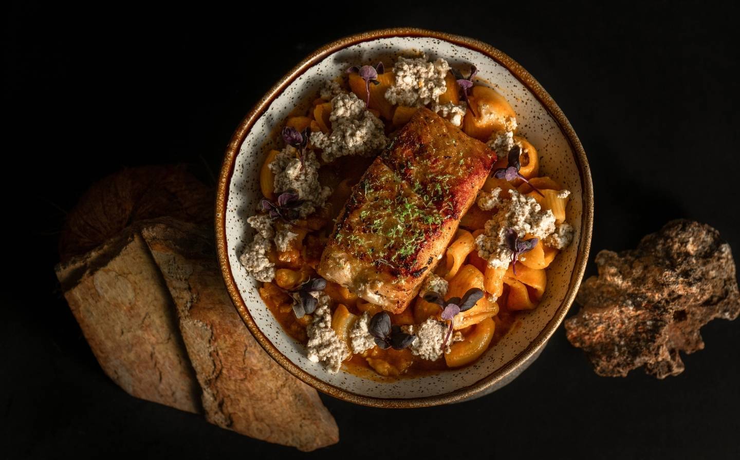 Un tazón de comida colorida sobre una superficie negra, representando La Filosofía: Más Allá de la Comida, una Narrativa de Origen.