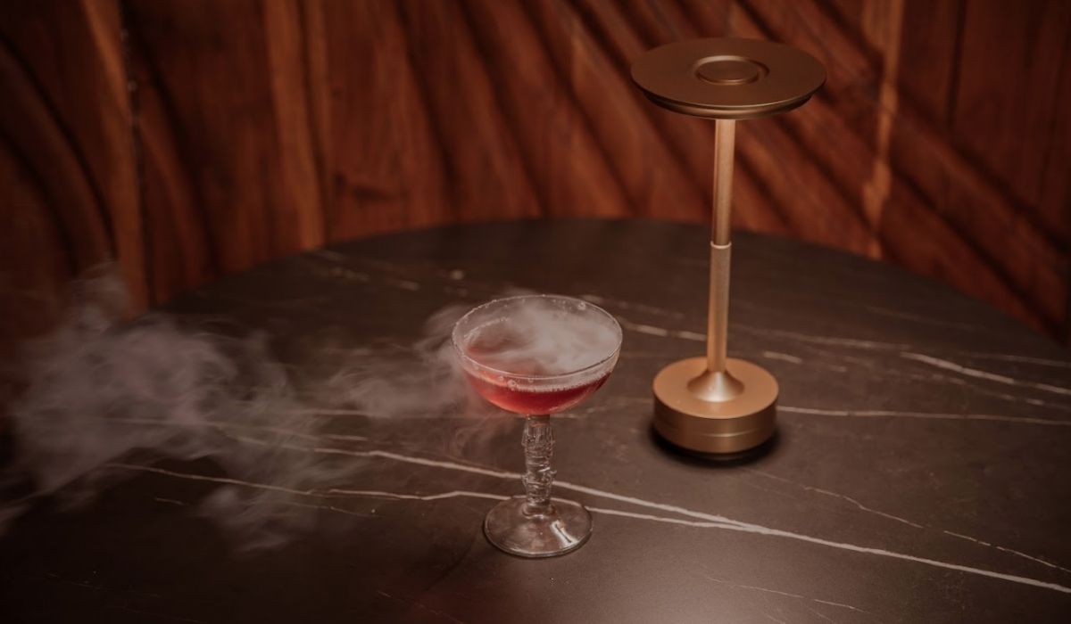 A cocktail in a glass, with smoke rising, suggesting an intriguing and sophisticated atmosphere.
