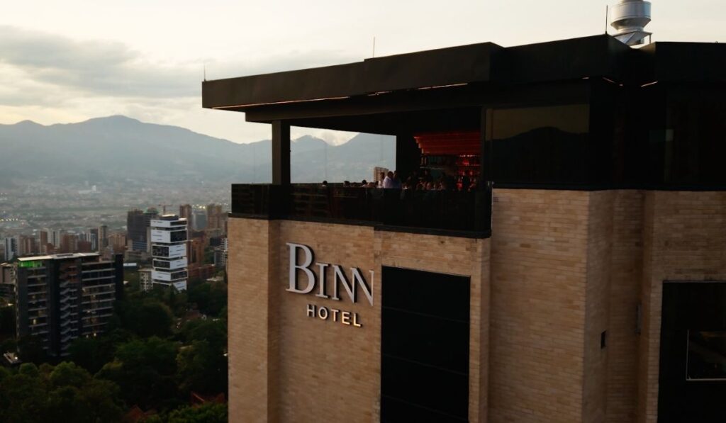 Vista aérea de Binn Hotel, con montañas en el fondo y un paisaje urbano en primer plano.