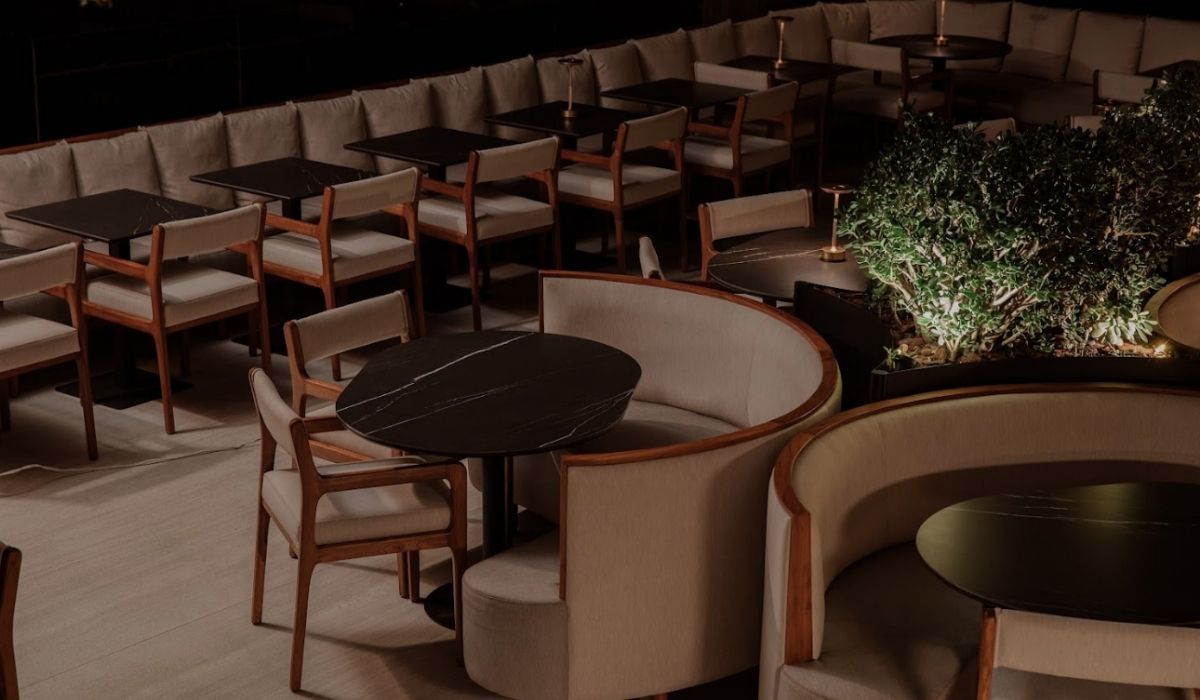 Interior of a restaurant with tables and chairs arranged in the middle of the space.