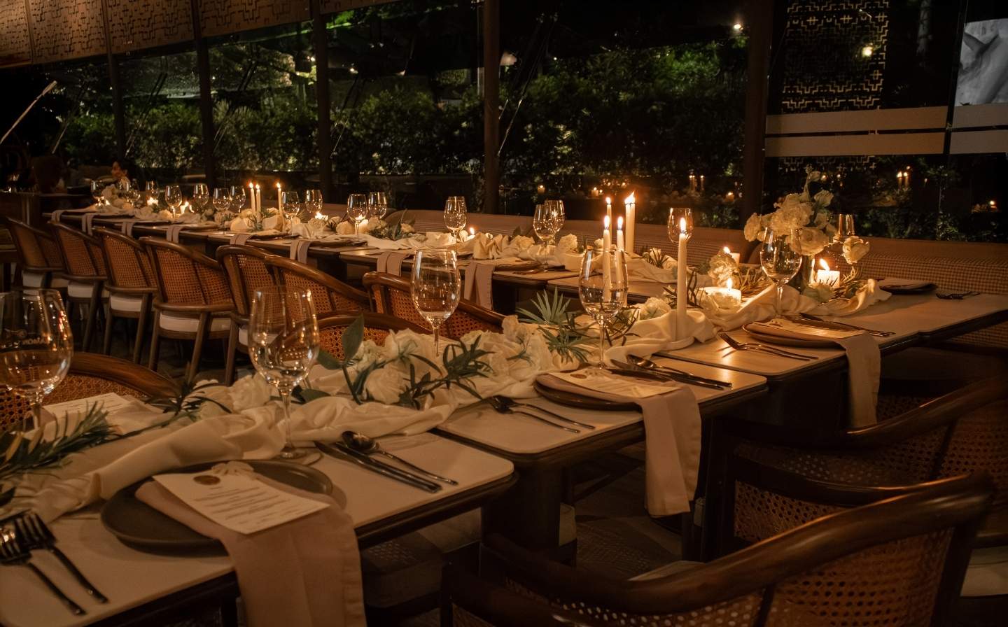 Mesa larga decorada con velas y cubiertos, lista para una cena elegante como la boda soñada