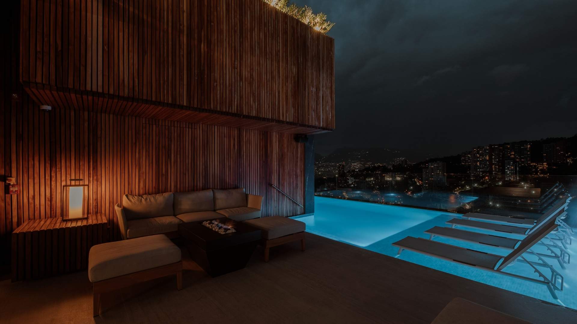 A pool with a wooden deck and panoramic views of the city is ideal for relaxing in Medellín.