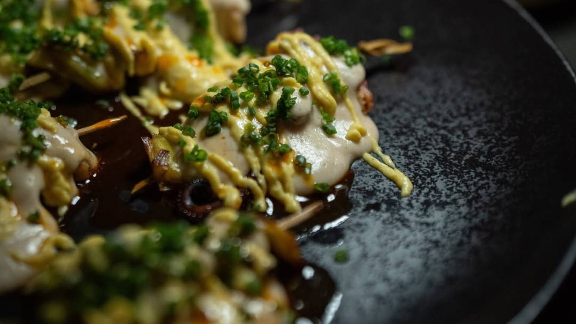 Un plato con comida y cebollitas verdes, ideal para compartir en Etro.
