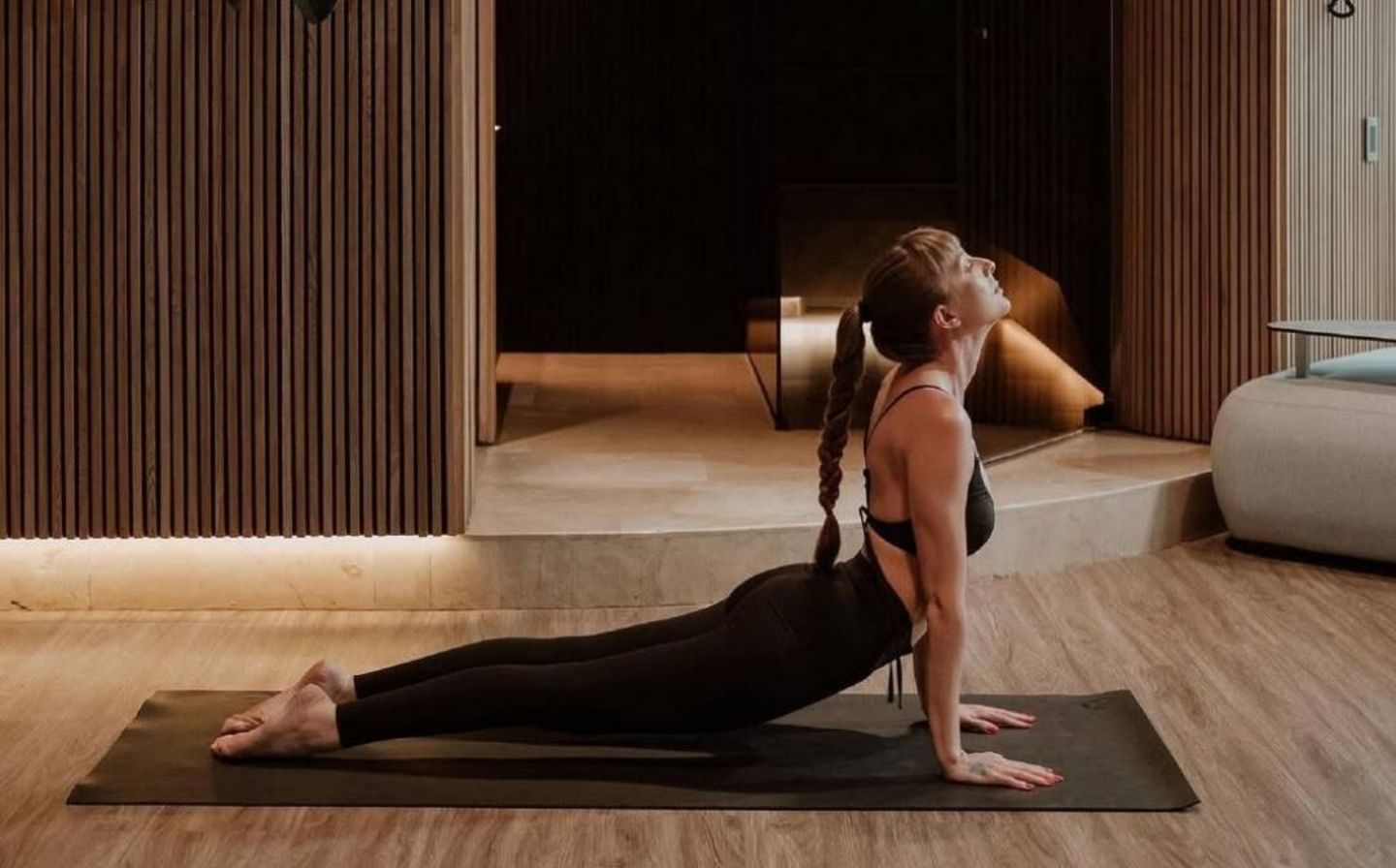 Mujer practicando yoga en una sala, promoviendo actividades de bienestar en Medellín