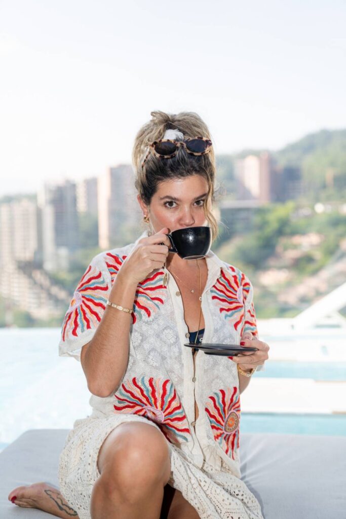 Mujer sentada en un sofá disfrutando de una taza de café en el brunch en el Etro Rooftop.
