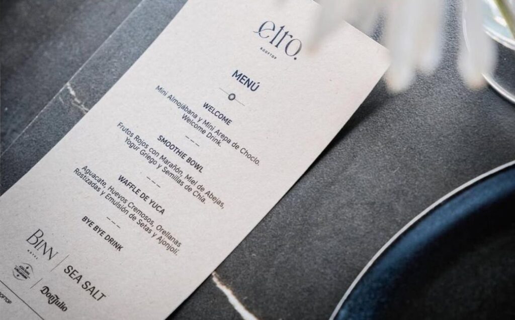 Menú sobre una mesa decorada con una flor, destacando las celebraciones especiales en Etro