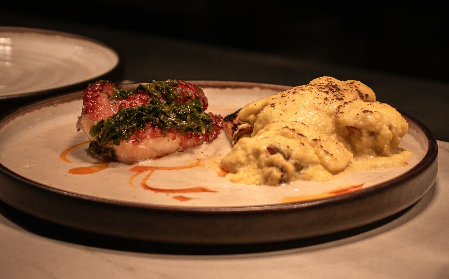 Un plato con comida colorida sobre una mesa, representando la cocina de raíz
