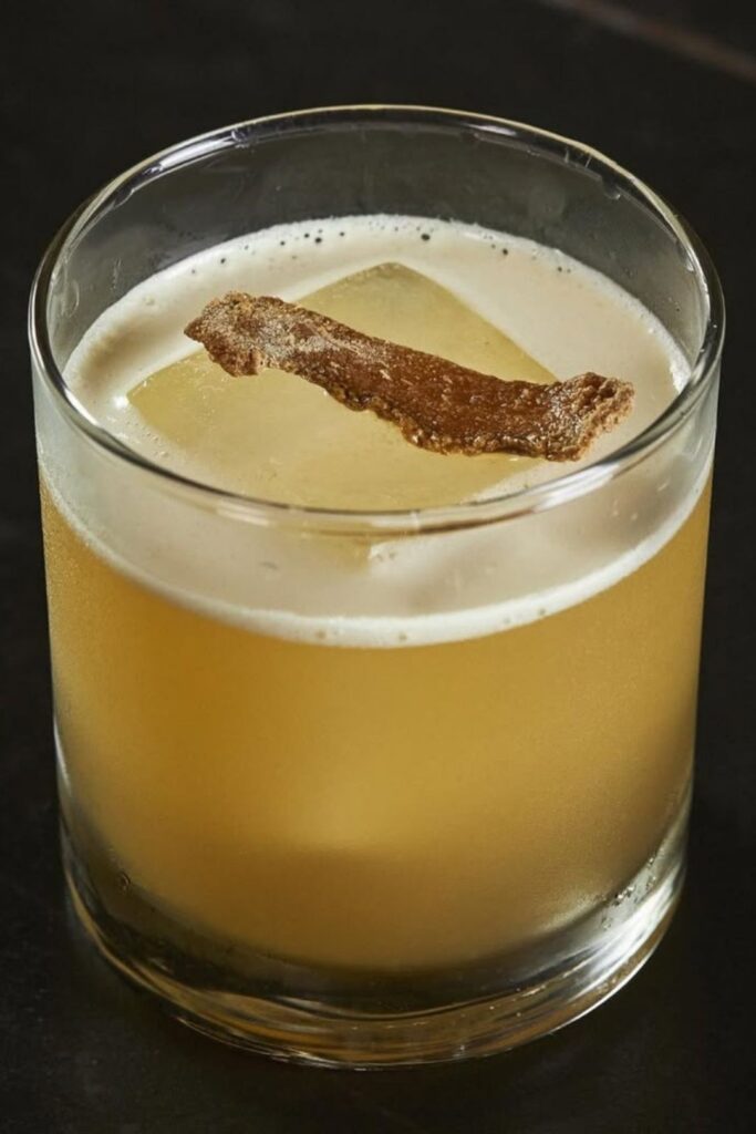 Un cóctel decorado con una ramita de canela, de La Makha, listo para disfrutar