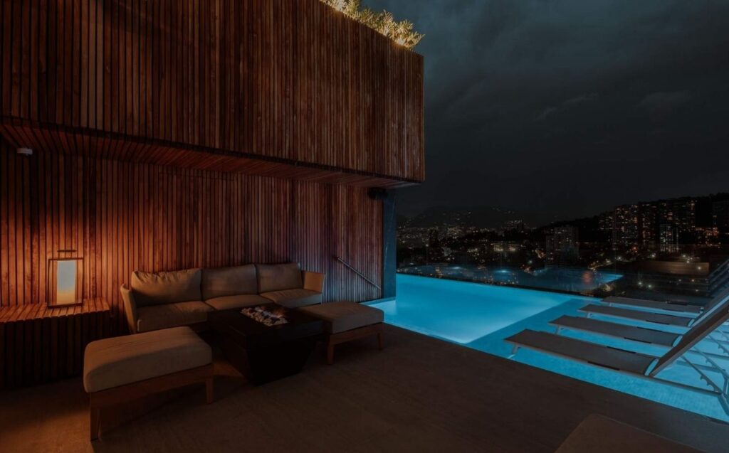 Área de piscina y lounge iluminada por la noche, con un diseño íntimo de Etro que invita a la relajación