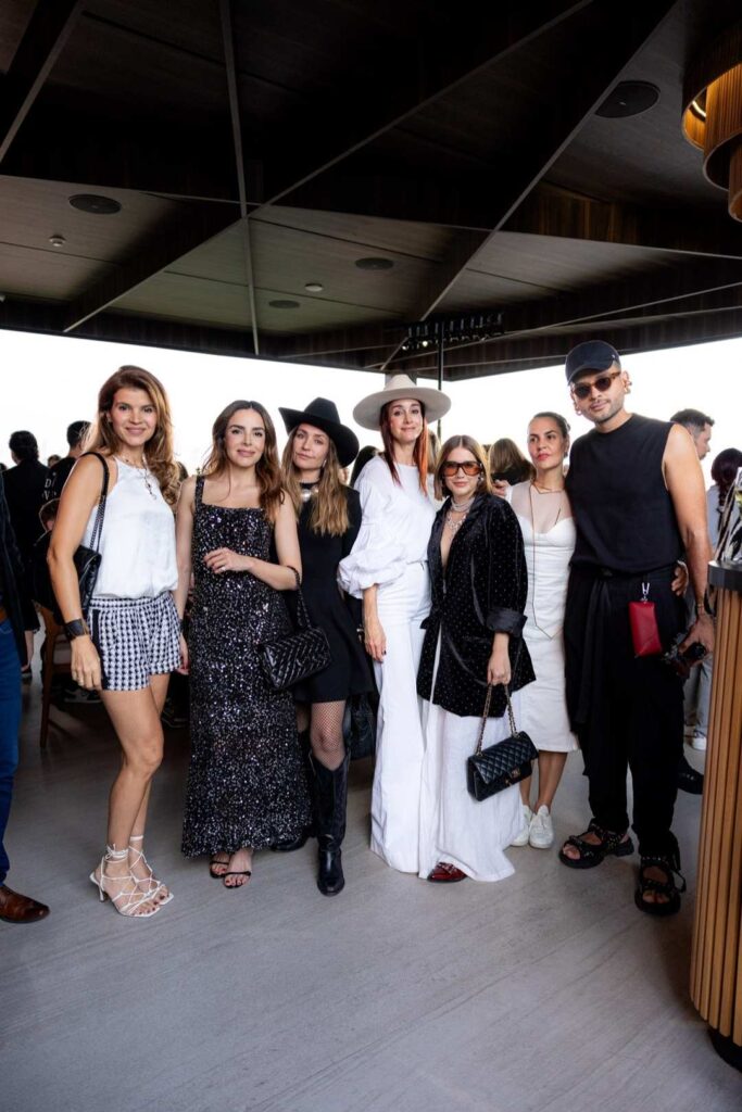 Grupo de personas sonriendo y posando para una foto en una fiesta de evento corporativo en las alturas.