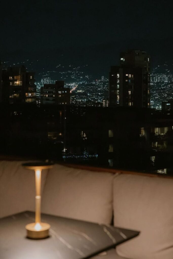 Mesa con lámpara, vista de la ciudad al fondo, en una fotografía arquitectónica de Etro