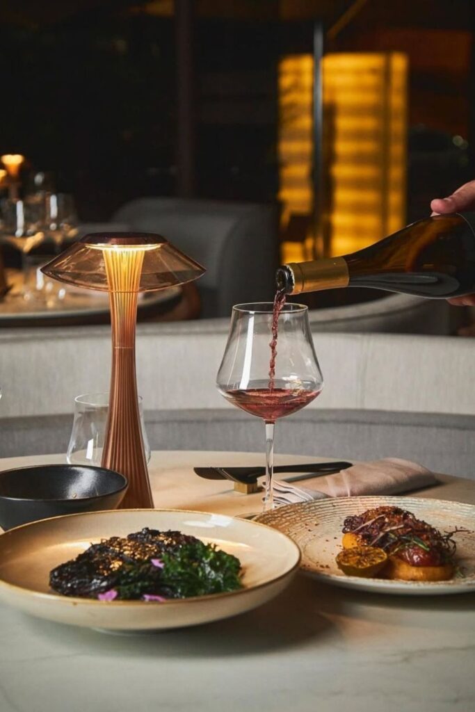 A person pouring wine into a glass at the upmarket BINN Gastronomy restaurant in El Poblado.