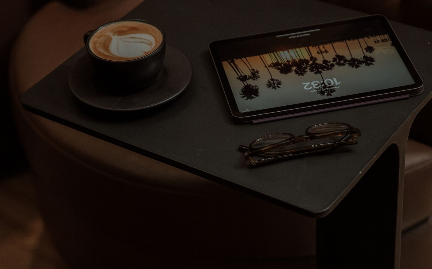 A tablet and a steaming cup of coffee sit on a wooden table, perfect for digital nomads enjoying a cozy workspace