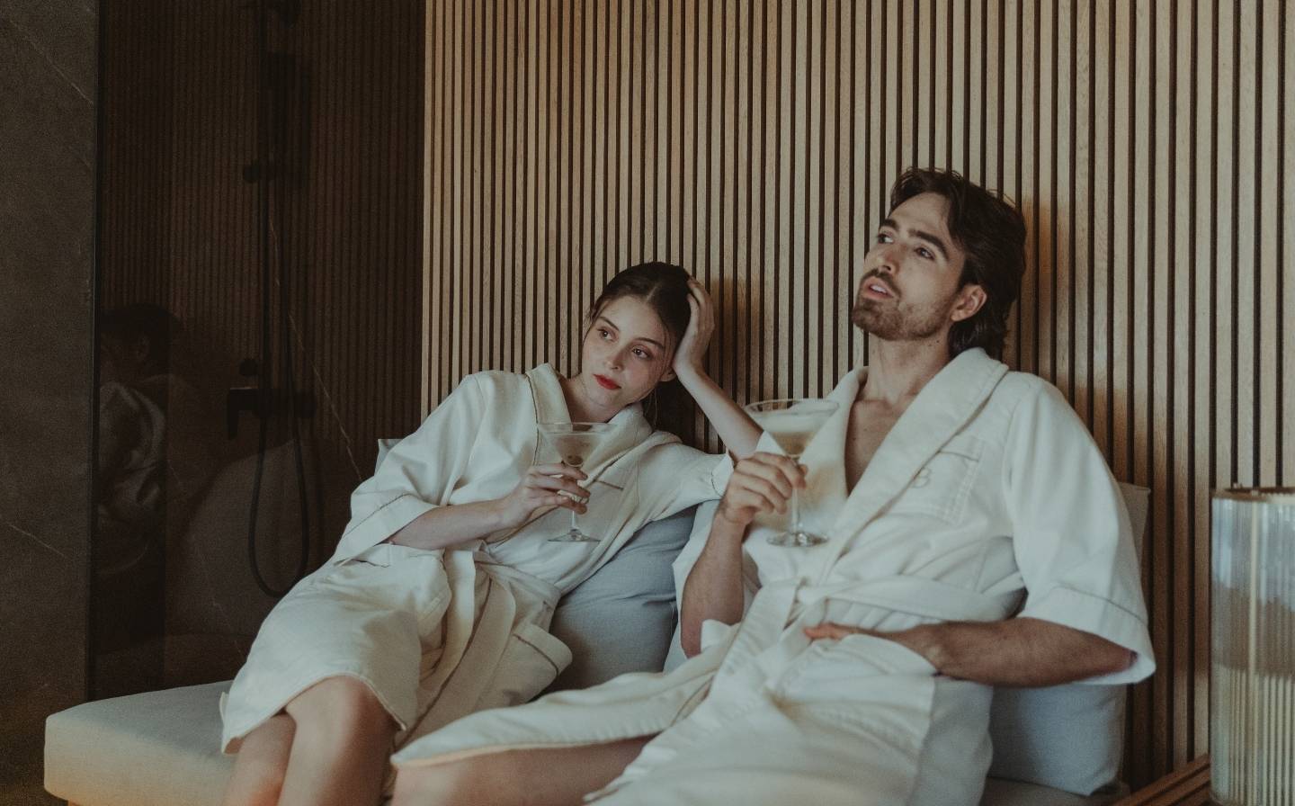 Man and woman in bathrobes sitting on a sofa, enjoying a romantic moment in Medellín