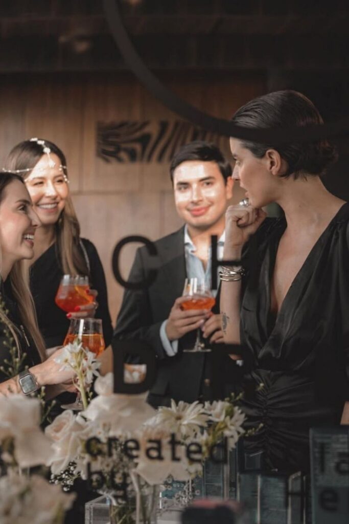 Un grupo de personas disfruta de bebidas en una fiesta en la Reserva VIP del Etro Rooftop