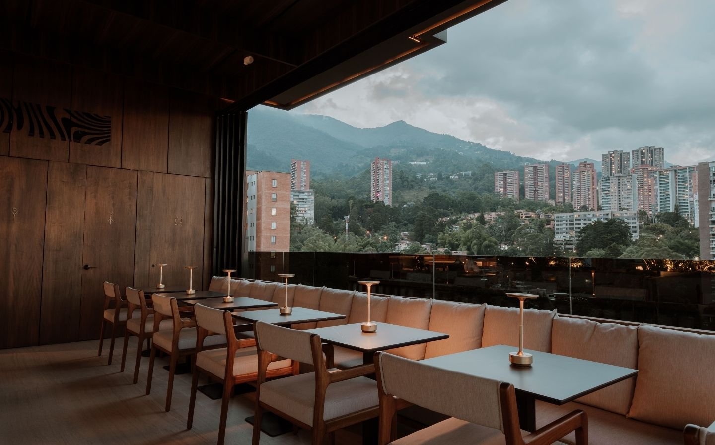 Vista de un restaurante que combina montañas y la ciudad, ofreciendo un ambiente acogedor y vistas impresionantes