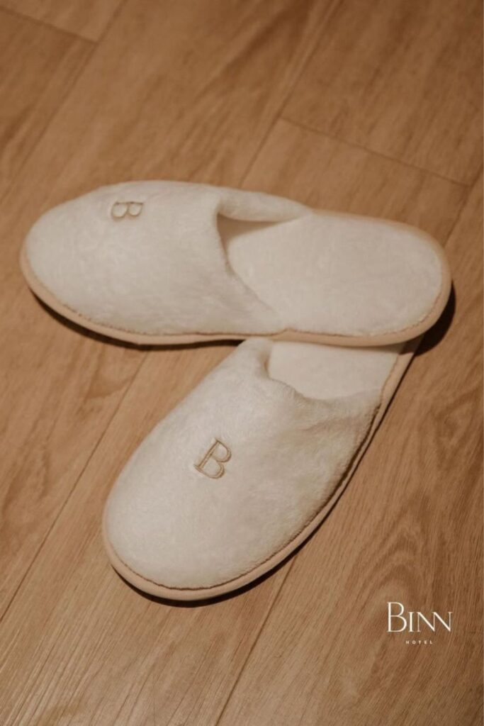 A pair of slippers with the letter b, representing luxury and well-being in the home