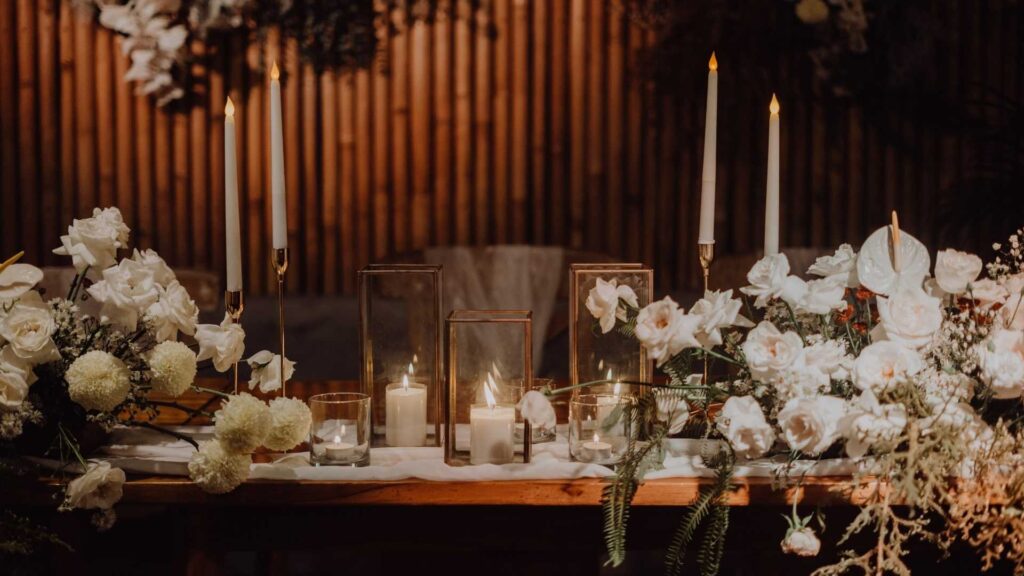 Mesa decorada con velas y flores, ambientada para una boda navideña en Medellín.