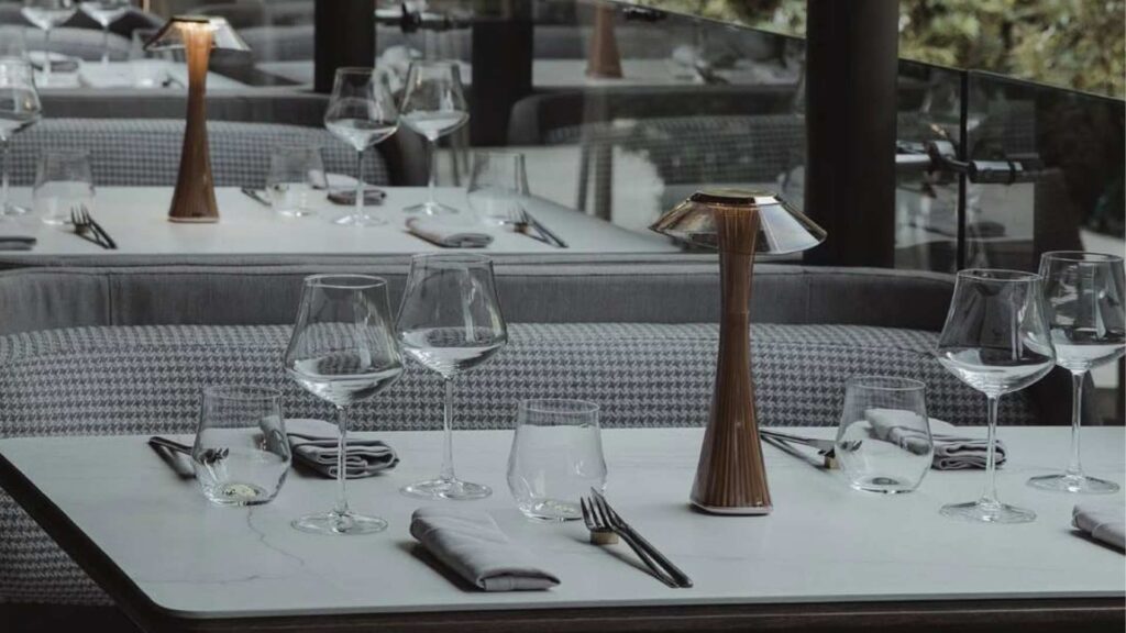 Mesa de restaurante con copas de vino y cubiertos. La Makha.