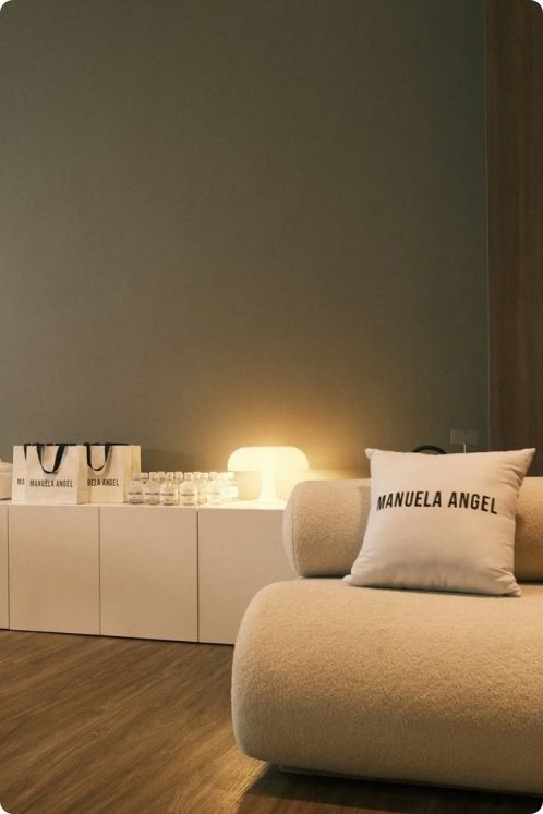 Sofá con un cojín y una lámpara en la pared, creando un ambiente acogedor para el bienestar en Medellín.