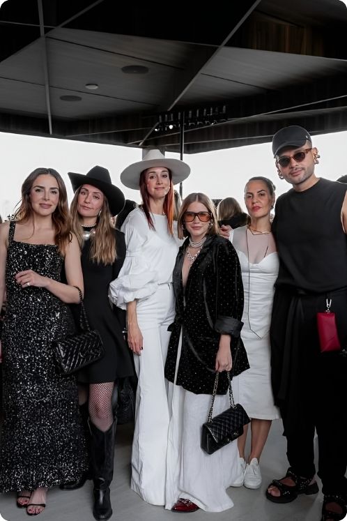 Un grupo de personas posando sonrientes en una fiesta en la azotea