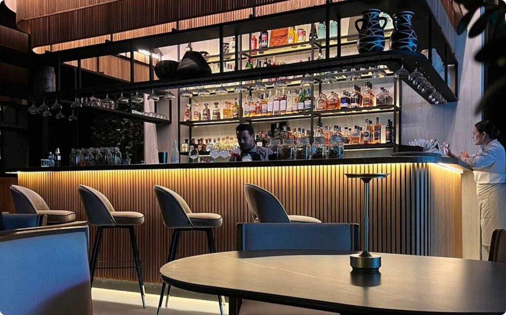 Un bar con una barra, mesas y sillas.