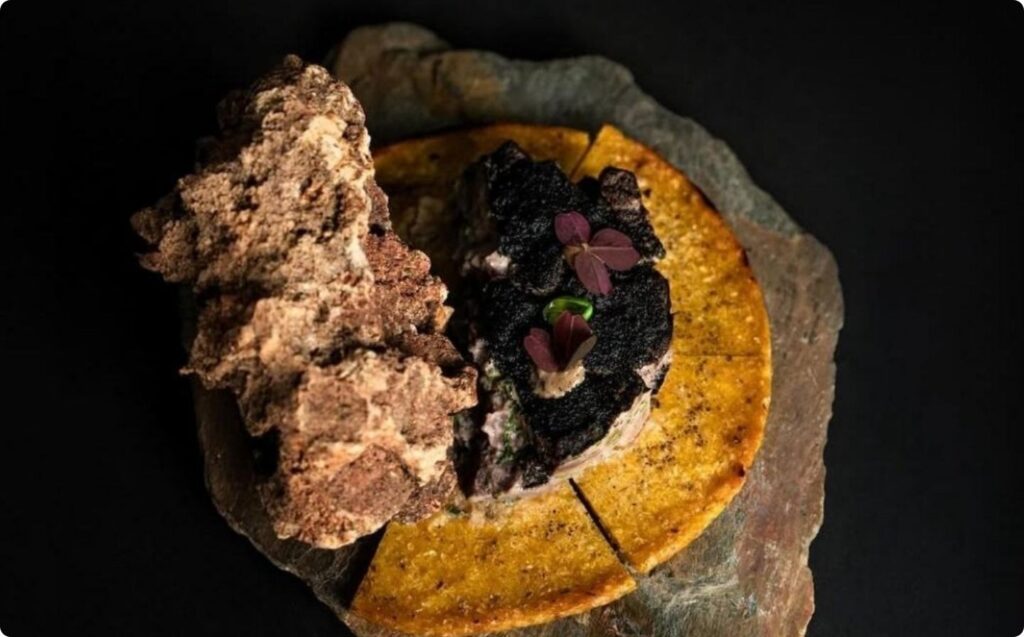 Un trozo de pastel sobre una tabla de madera, decorado con un estilo exótico y criollo.