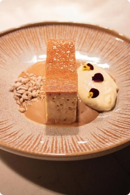 A gourmet dessert on a plate, accompanied by a spoon