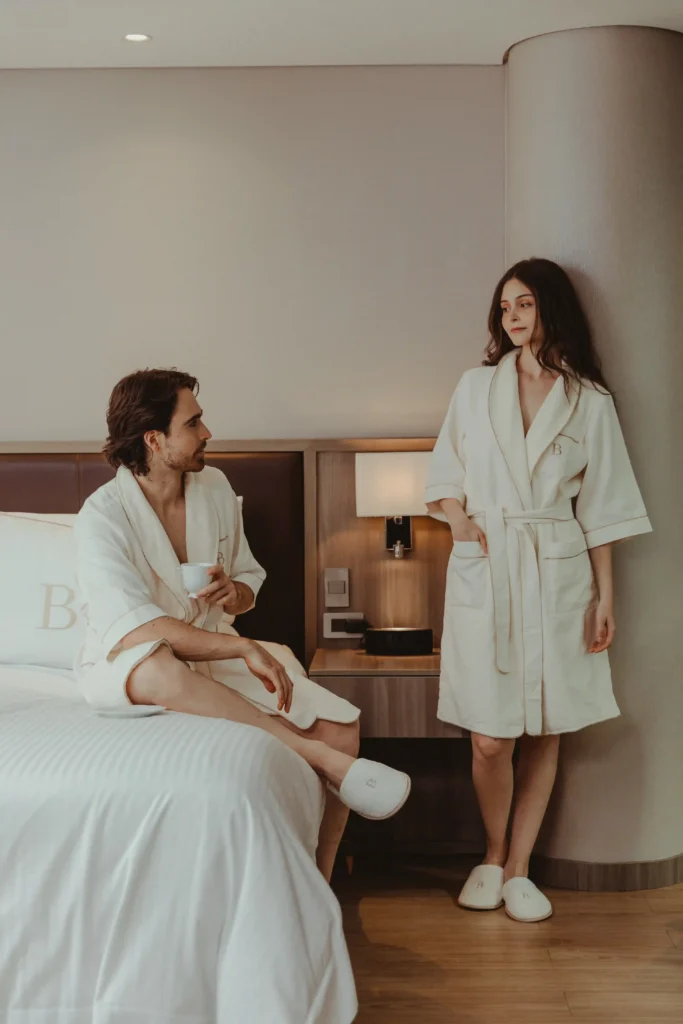 Pareja en batas en la suite de lujo de Binn Hotel Medellin, ideal para noche de bodas o luna de miel.