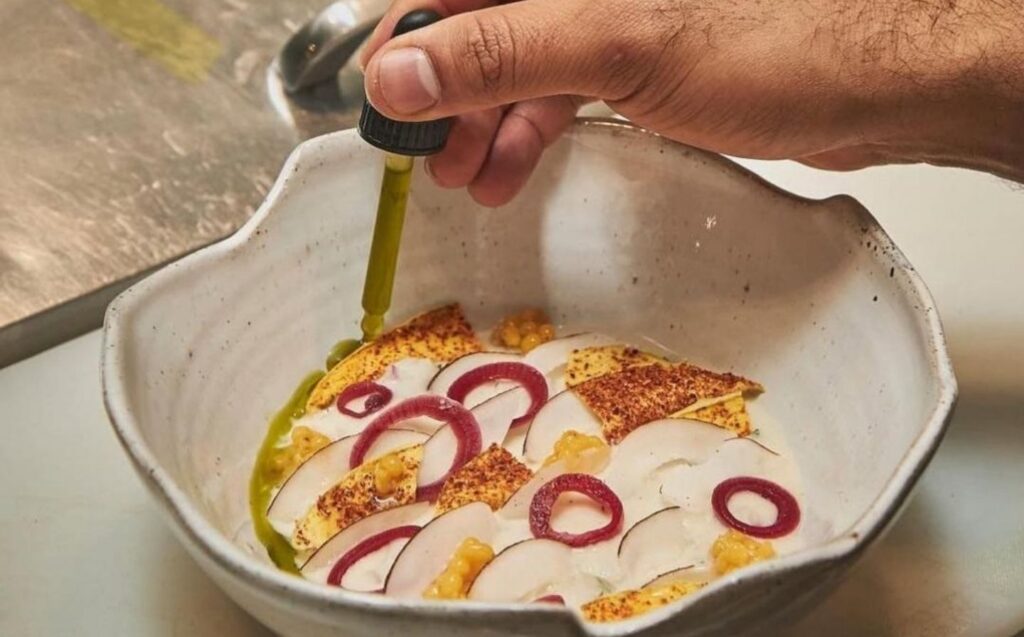 Persona cortando comida en un bol con un cuchillo.
