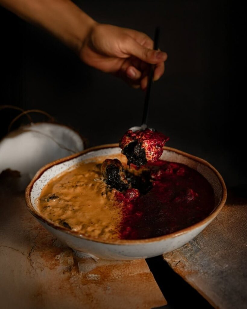 Person holding a spoon over a bowl of vegan food
