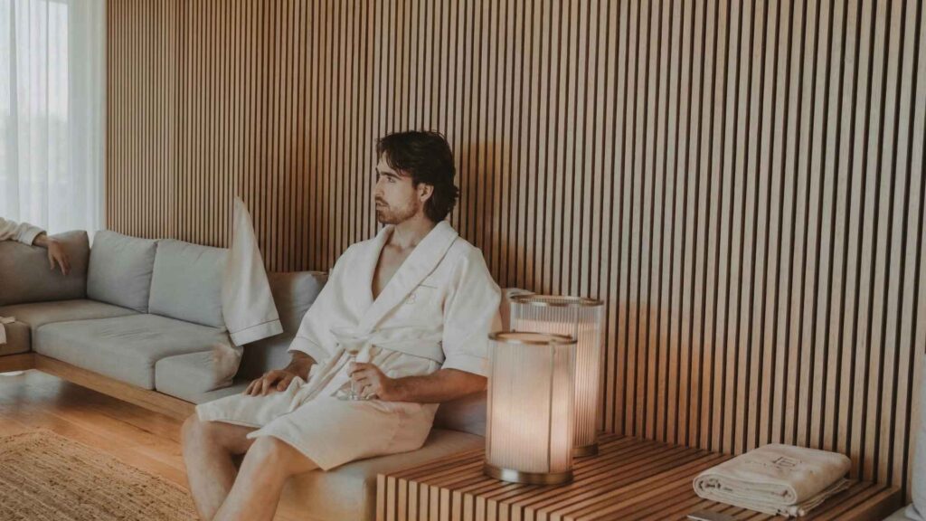 Ejecutivo en spa de hotel de lujo en Medellín, disfrutando ambiente relajante ideal para viajes de negocios y bienestar.