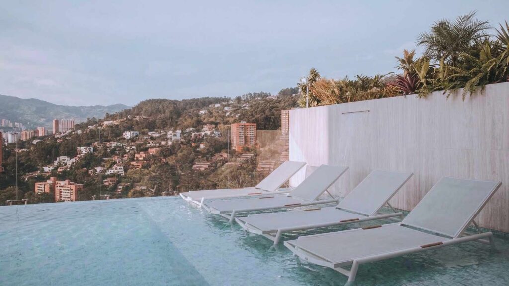 Piscina infinity de hotel de lujo en Medellín con vista panorámica a la ciudad y zona de descanso premium en rooftop
