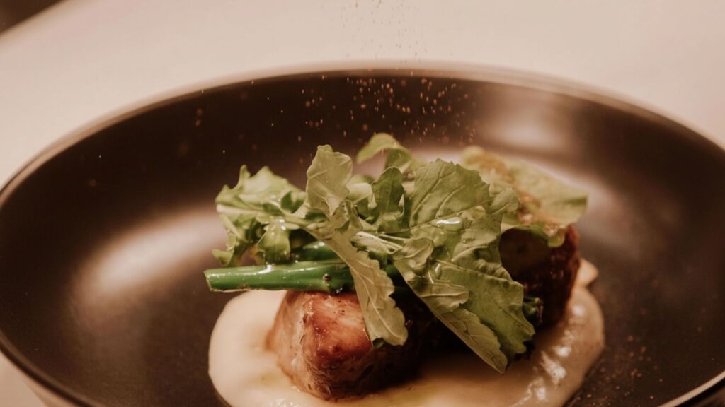 Un plato con comida decorado con un toque de sal.