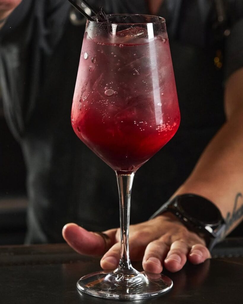 A bartender serves a drink in a glass..