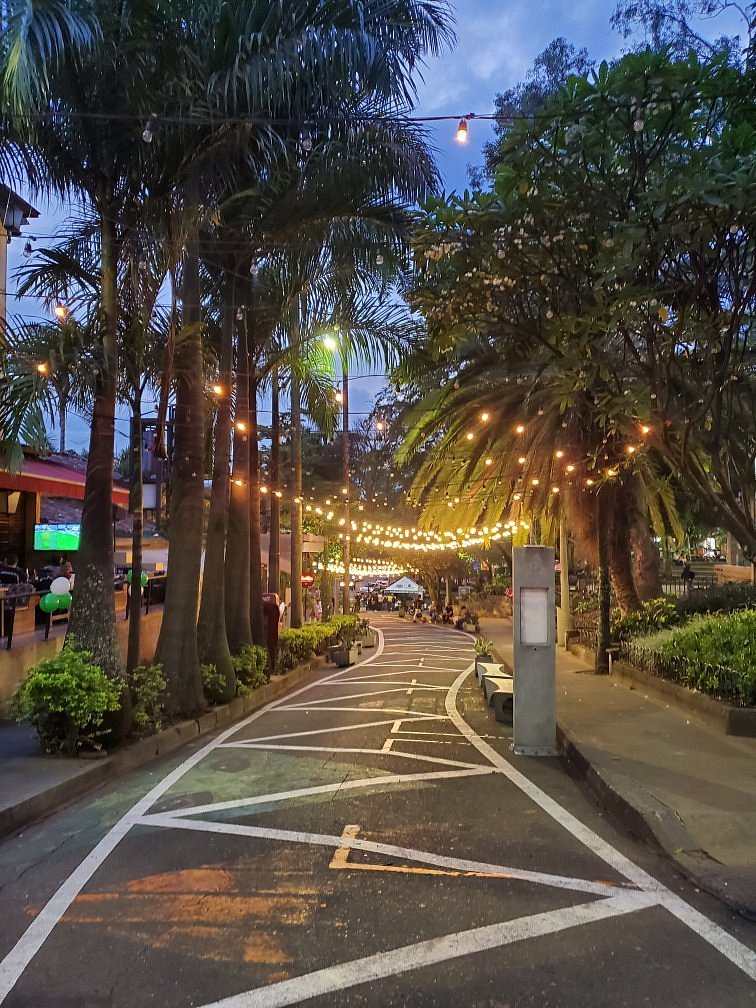 Parque Lleras en Medellín iluminado de noche con restaurantes y vida nocturna, ubicación estratégica para hospedarse