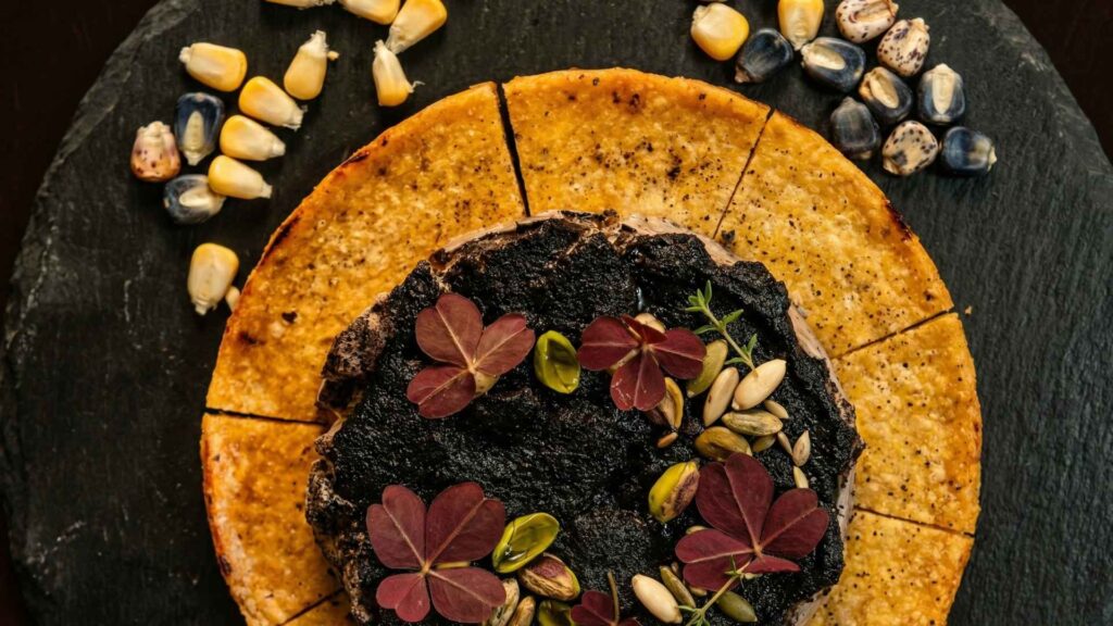 Un plato con un hongo negro y hojas frescas