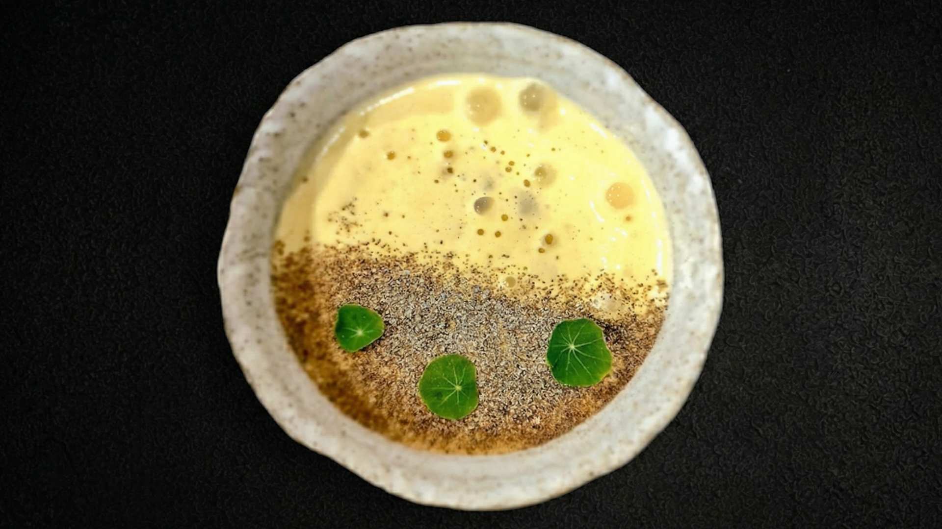 Un tazón de sopa con una hoja verde encima, sin gluten.