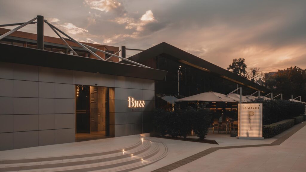 Fachada exterior del Hotel Binn y restaurante La Makha en Medellín, arquitectura moderna con terraza iluminada al atardecer.