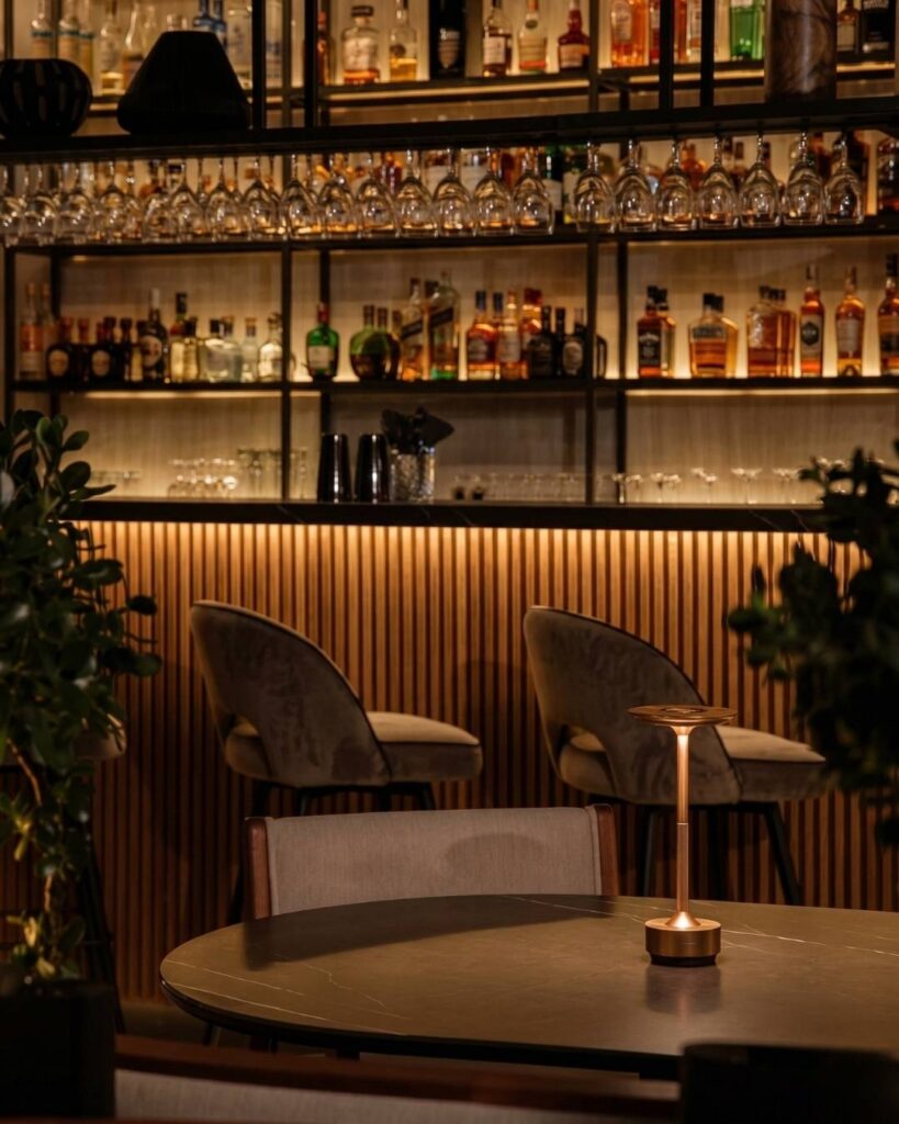 Bar rooftop en Medellín con iluminación cálida, coctelería premium y ambiente sofisticado para salir de noche