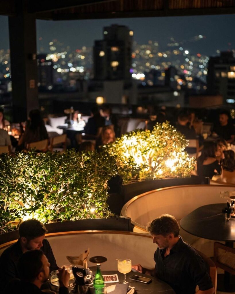 Rooftops en Medellín para salir hasta tarde con vista nocturna, mesas iluminadas, cócteles y ambiente social elegante en terraza urbana.
