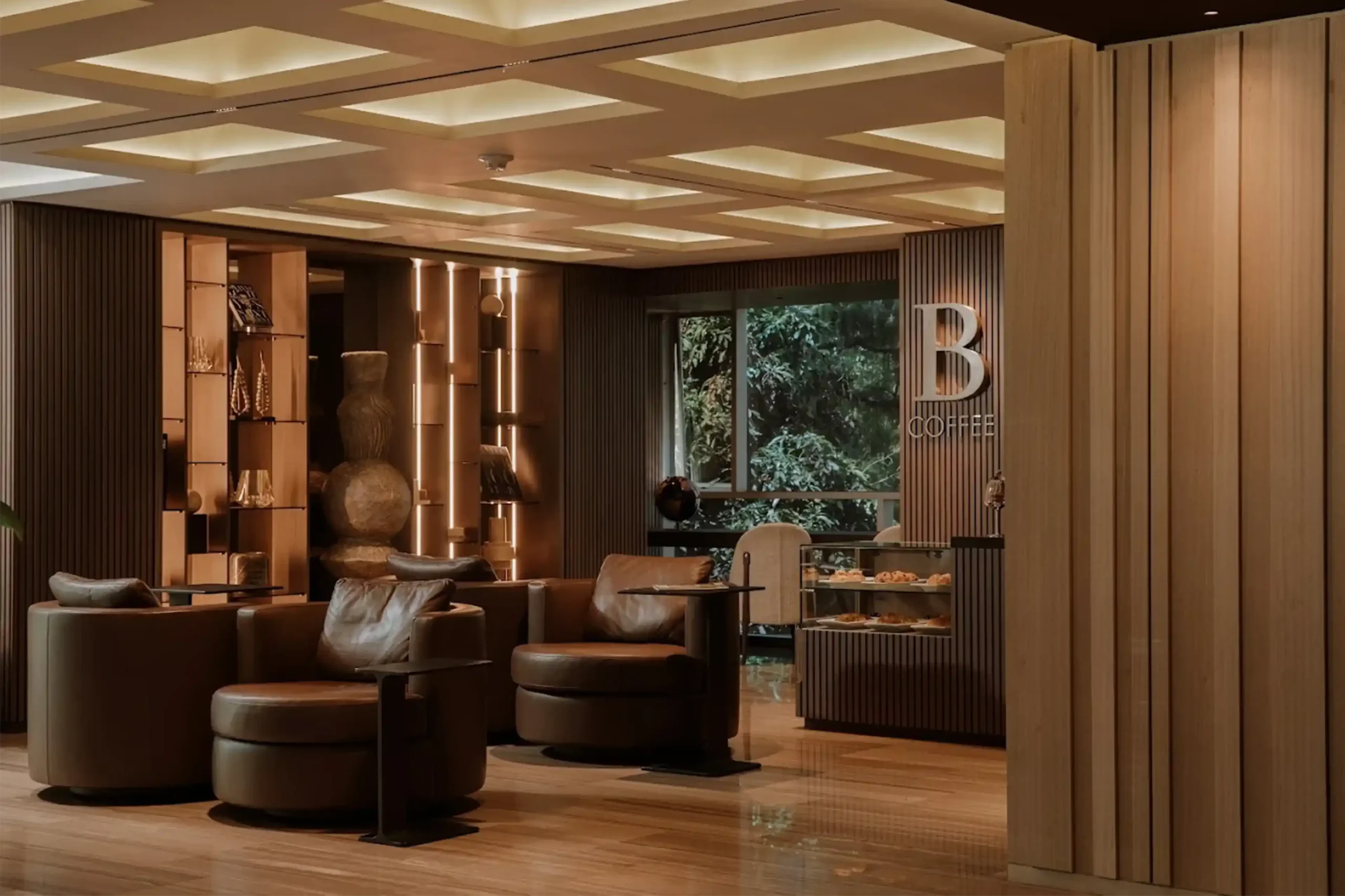 Lounge de B-Coffee con sillones de cuero y diseño moderno en un hotel de lujo en Medellín.