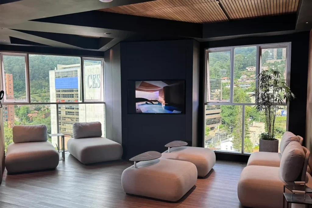 Área lounge de Binn Hotel en Medellín con diseño moderno y ventanales panorámicos con vista urbana.
